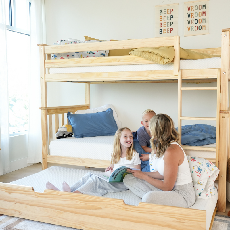 Child in green shirt and orange shorts lying on a textured white surface.