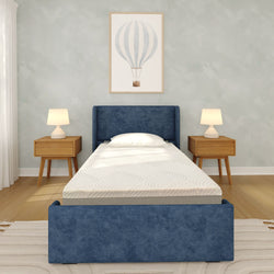 Modern minimalist bedroom with blue upholstered twin bed and mattress, wooden nightstands with lamps, hot air balloon wall art and hardwood floor