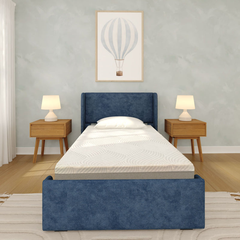 Modern minimalist bedroom with blue upholstered twin bed and mattress, wooden nightstands with lamps, hot air balloon wall art and hardwood floor