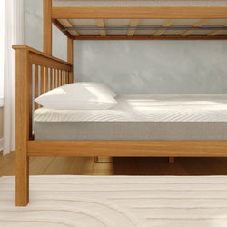 Light wood bunk bed frame with twin mattress and white pillow in a bright minimalist bedroom