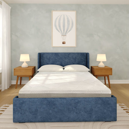 Blue upholstered platform bed with white mattress in modern bedroom, wood mid-century nightstands, table lamps and hot-air-balloon wall art