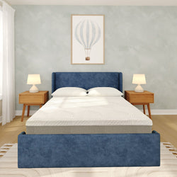 Modern minimalist bedroom with blue upholstered bed, white bedding, wooden nightstands with lamps, hot air balloon wall art and hardwood floors