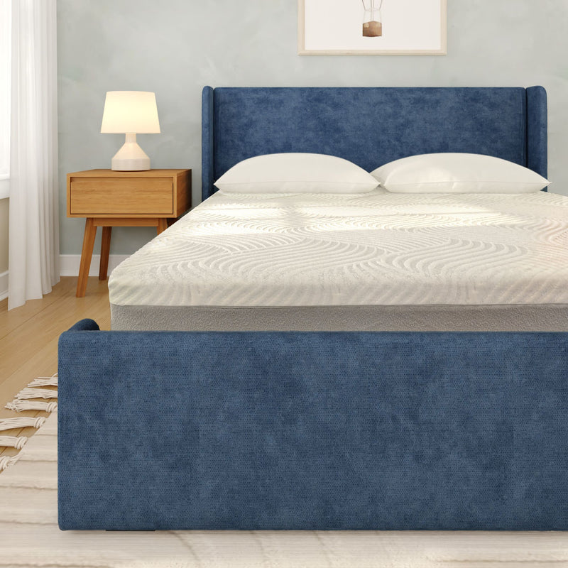 Modern blue upholstered bed frame with white mattress and pillows beside wooden nightstand and lamp in a bright minimalist bedroom