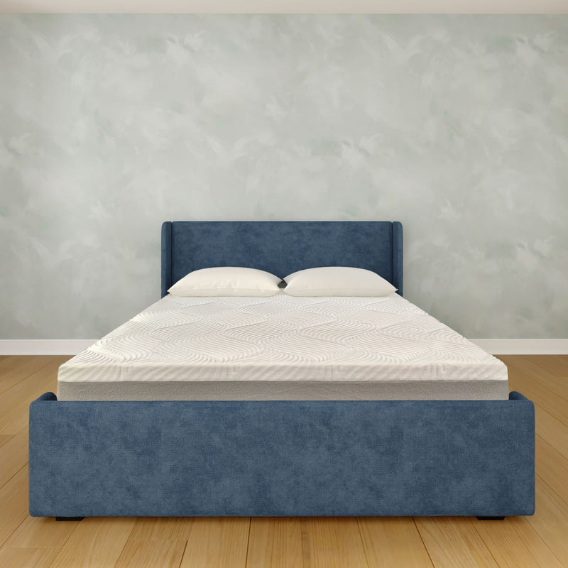 Modern minimalist bedroom: blue upholstered platform bed with white mattress and pillows on light hardwood floor against a textured gray wall
