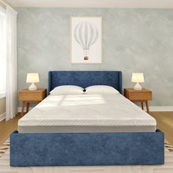 Modern minimalist bedroom with blue upholstered bed and headboard, white mattress and pillows, mid-century wooden nightstands with table lamps, hot-air balloon wall art and hardwood floors.