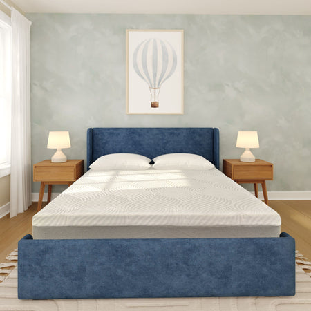 Modern minimalist bedroom with blue upholstered bed and headboard, white mattress and pillows, mid-century wooden nightstands with table lamps, hot-air balloon wall art and hardwood floors.