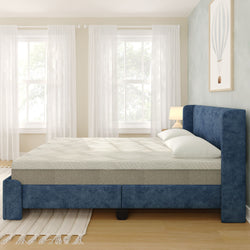 Modern navy upholstered bed with foam mattress and white pillows in bright minimalist bedroom with sheer curtains and hardwood floor