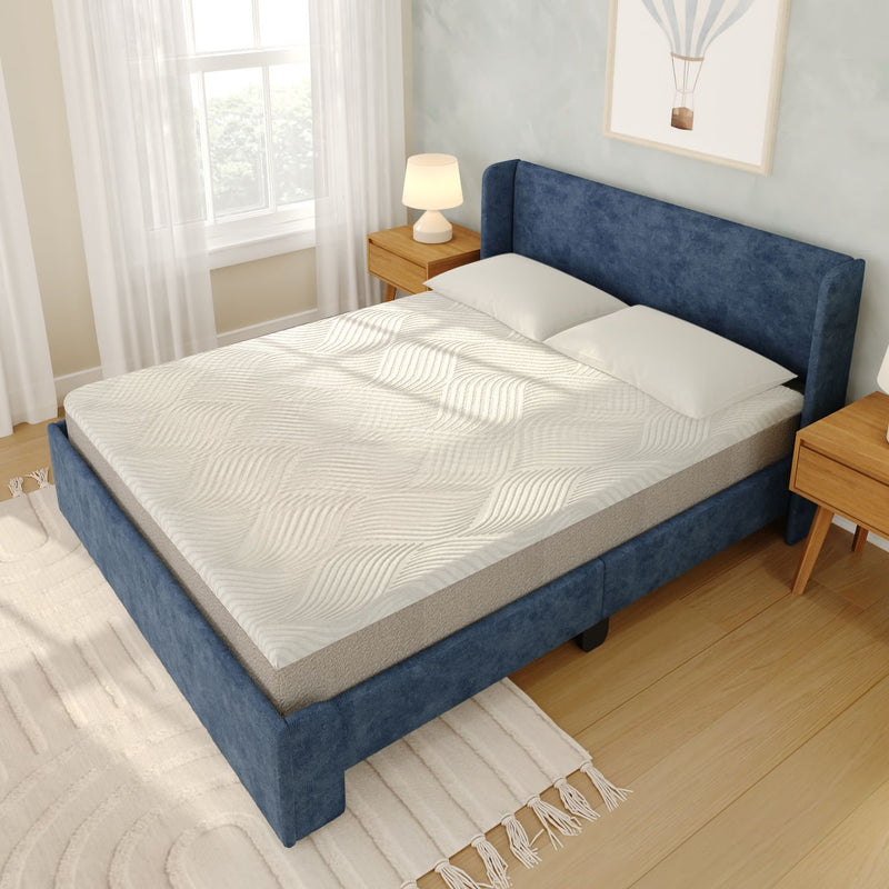 Modern blue upholstered bed with white textured mattress topper and pillows, wooden nightstands and lamp in a bright minimalist bedroom