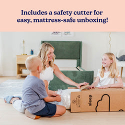 Mother and two children unboxing a mattress-in-a-box using a safety cutter in a bright bedroom with a green upholstered bed frame