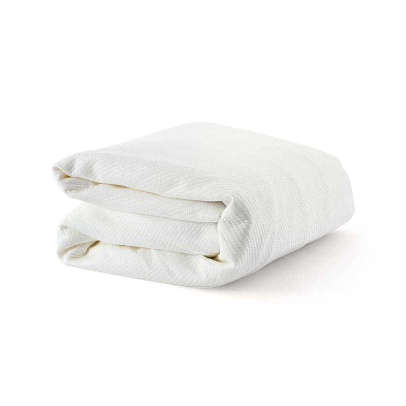 Folded white blanket made of soft, textured fabric on a clean background.