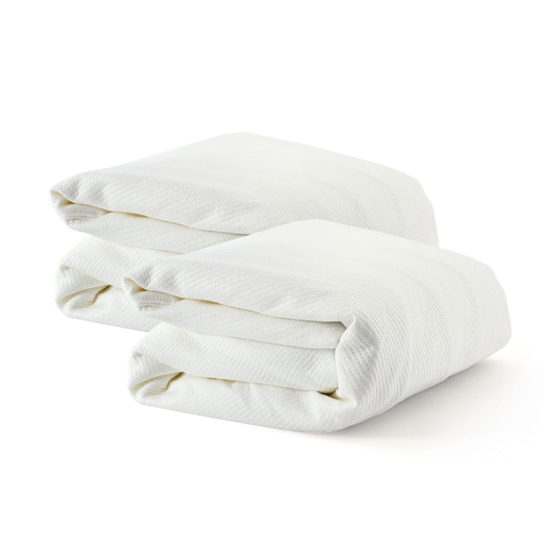Folded white cotton bedsheets on a white background.